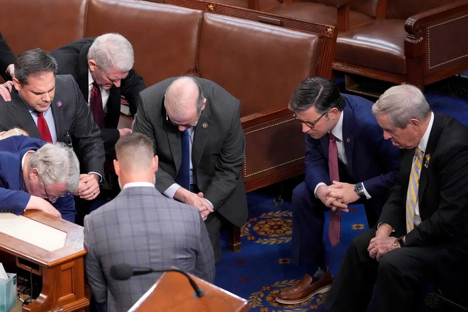 Members of Congress praying together on the House floor