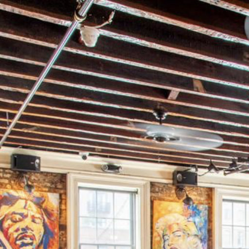 The Whiskey Room at Henry’s with exposed ceiling beams, fans and wall art