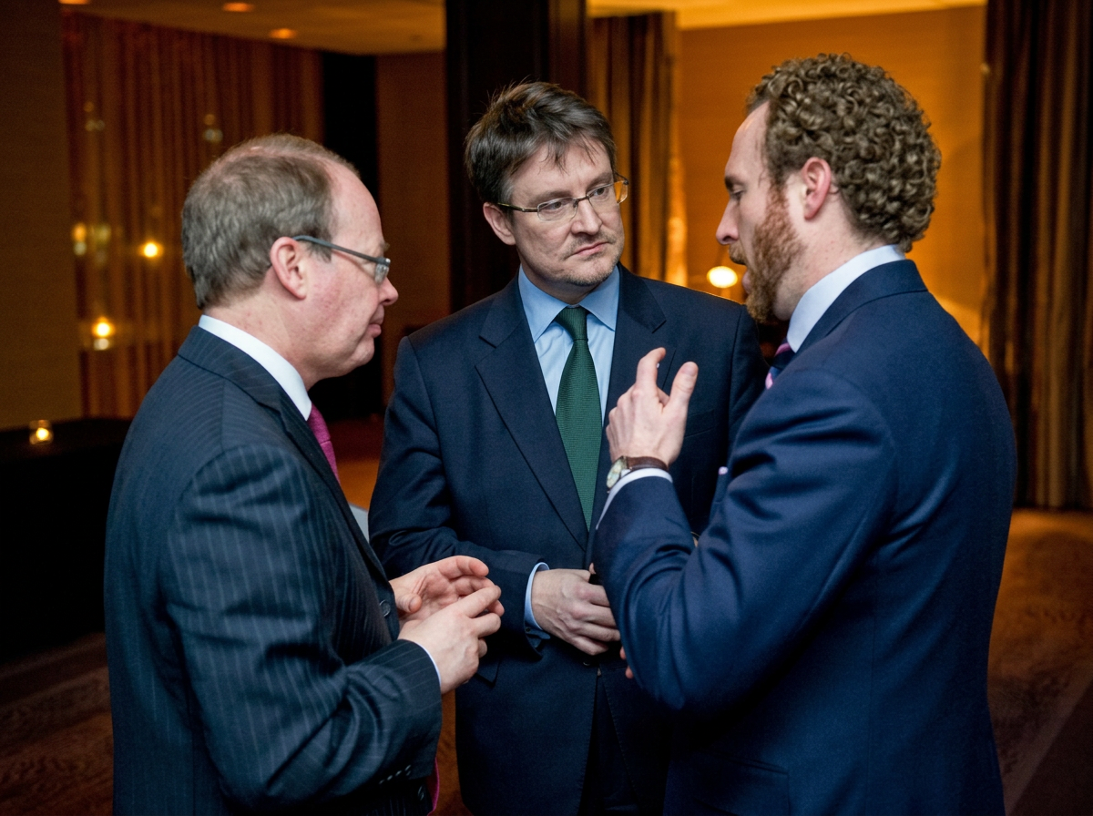 Three men in close conversation — listening to one another's stories