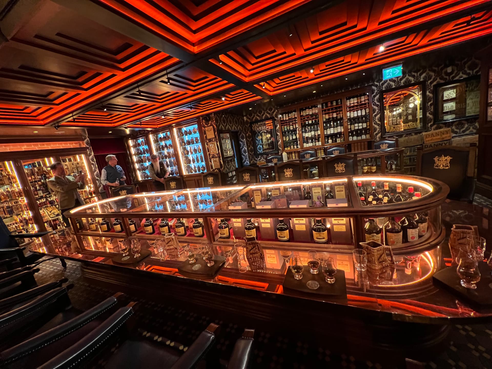 A warmly lit tasting bar lined with Irish whiskeys and glasses